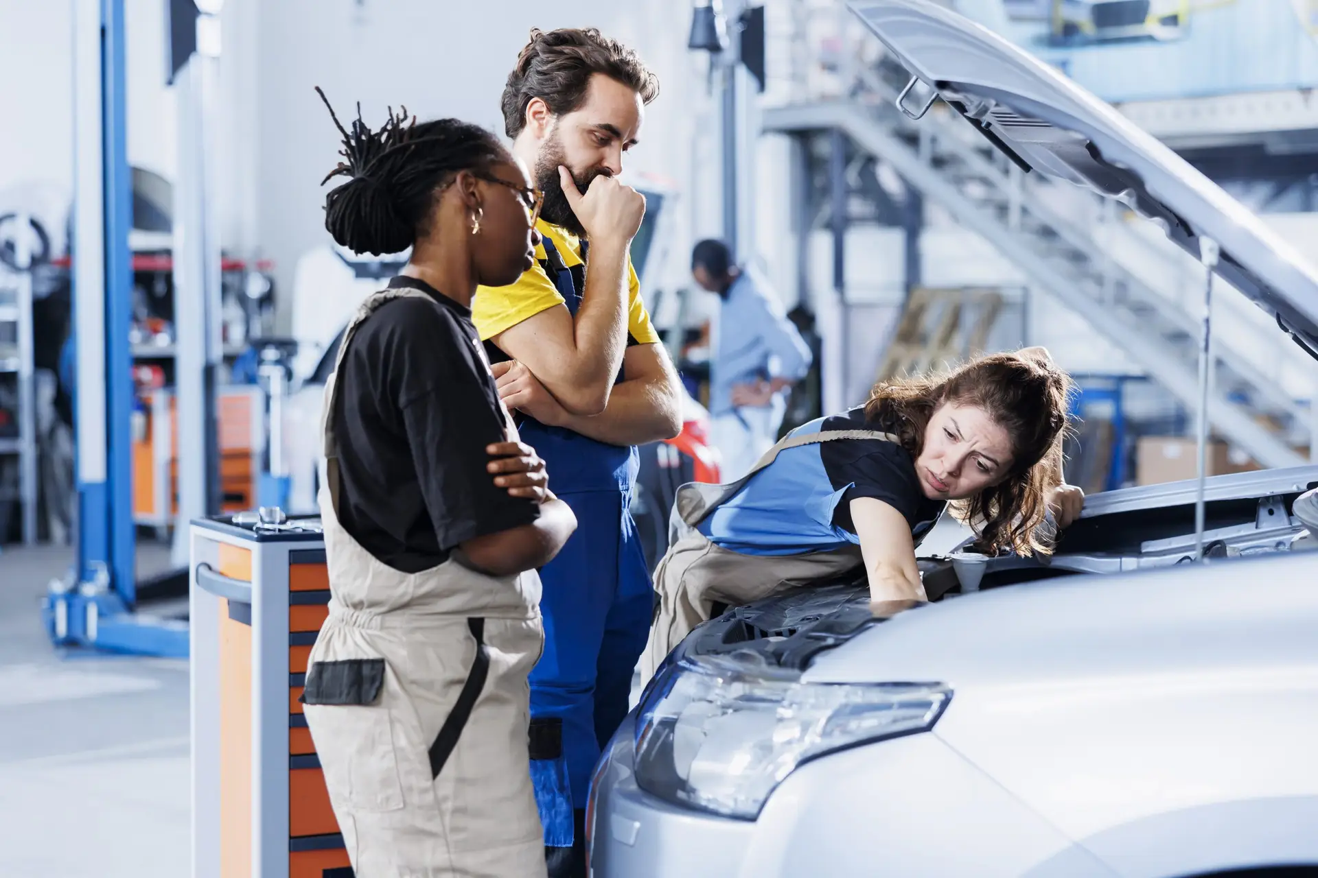 Repairmen fix car fuel tank together